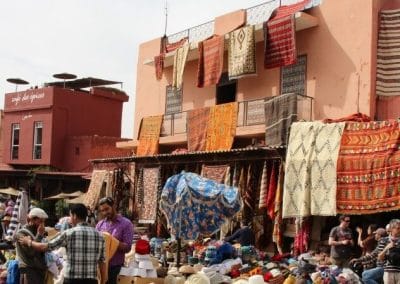 A group of people standing in front of stand with hats