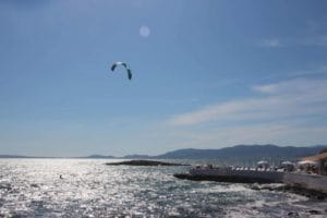 A man flying kite in a body of water