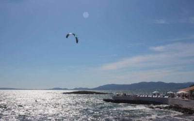 A man flying kite in a body of water