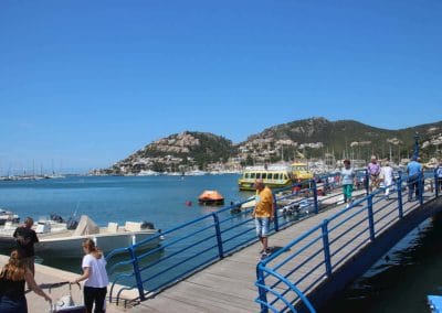 A group of people on a dock next to a body of water