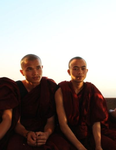 4 Mönche in roten Kutten auf Bank