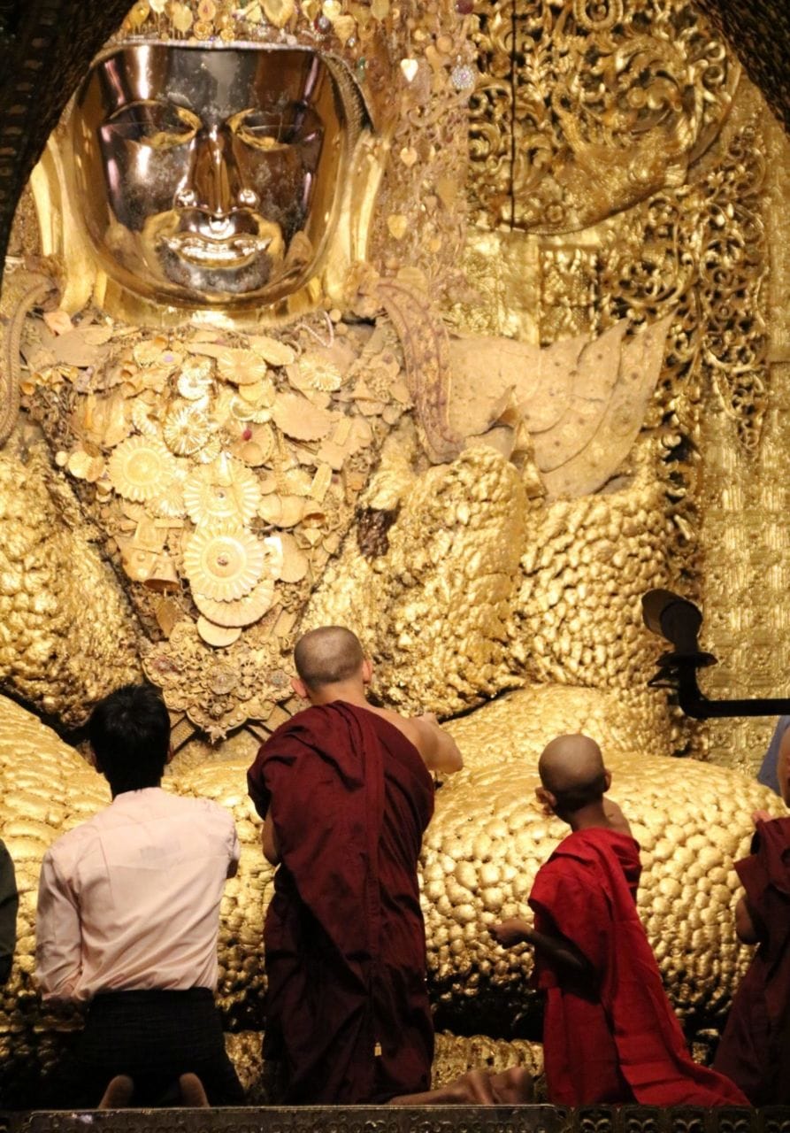Männer von hinten vor goldener Buddha Statue