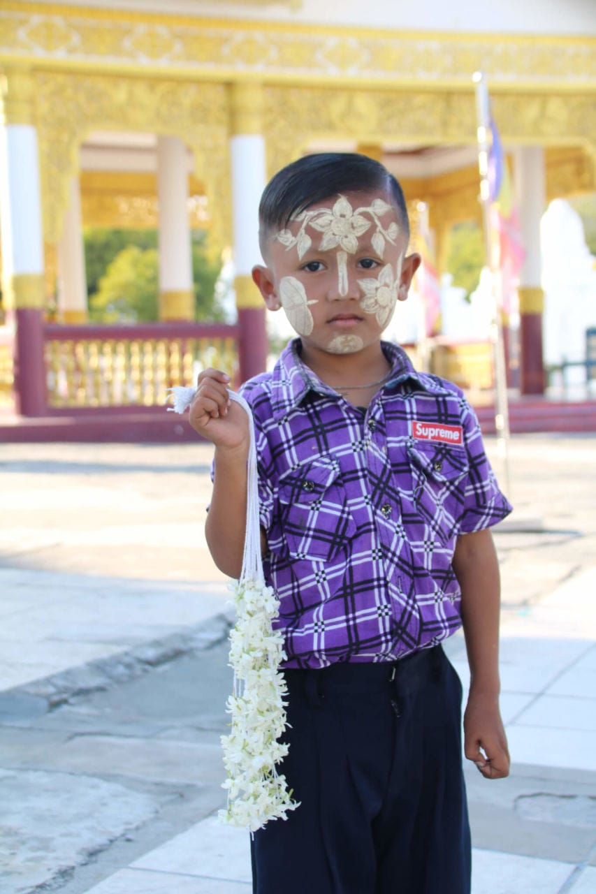 Kind mit Bemalung im Gesicht vor gelber Pagode