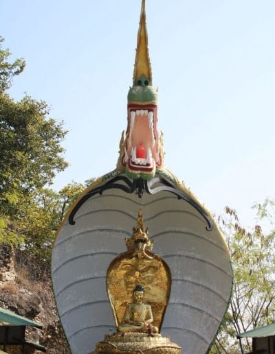 A large clock tower in front of a statue