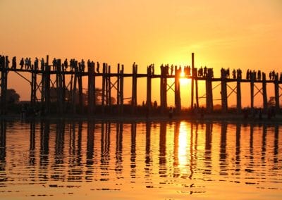 Menschen auf Holzbrücke in orangem Licht