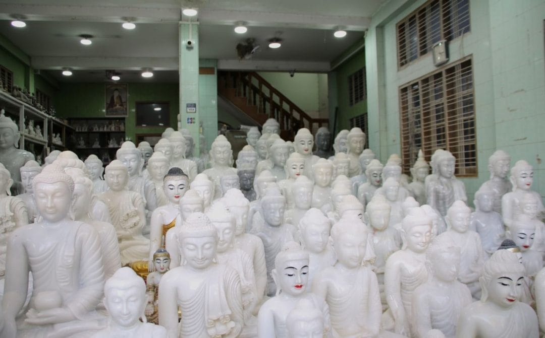 Weiße Buddhafiguren in einer Halle