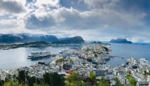 Stadt umgeben von Meer mit einem Kreuzfahrtschiff im Hintergrund