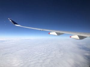 Ein Blick auf den Flügel eines Flugzeugs über den Wolken.