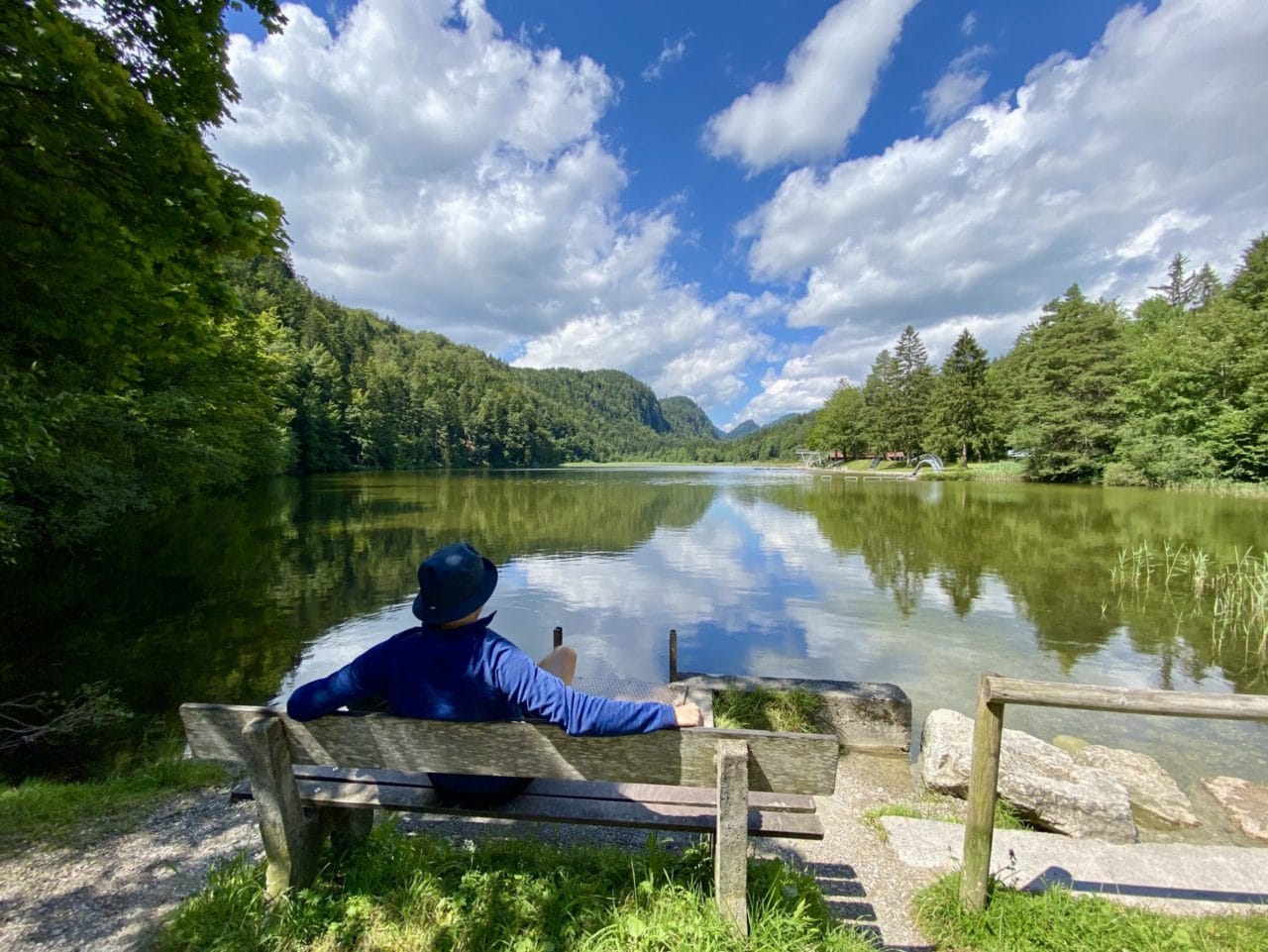 Ein Mann auf einer Bank vor einem See