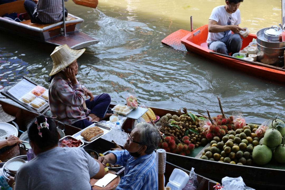 Die schwimmenden Märkte von Damnoen Saduak Thailand - Verkäuferin mit Handy Verkäuferin auf Boot telefoniert