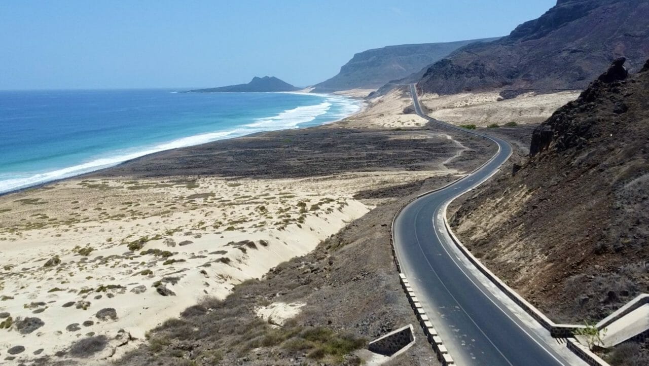 Sanddünen vor dem Meer und Bergen mit Straße