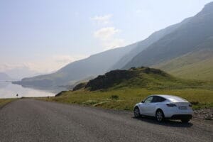 Ein Elektrofahrzeug vor einem Gebirge und See