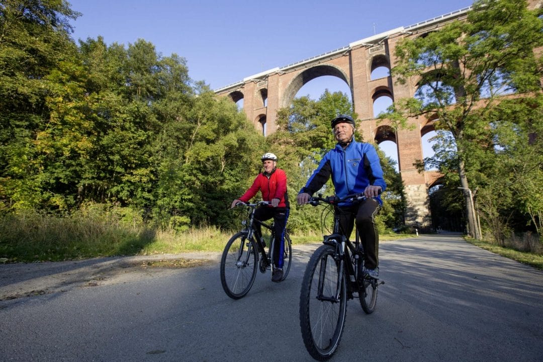 Ein Mann und eine Frau fahren mit dem Fahrrad in der Nähe einer Brücke.