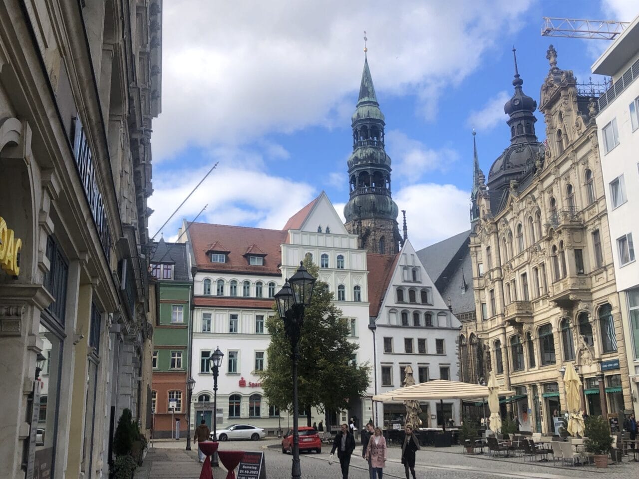 Zwei Menschen gehen eine Straße in einer Stadt entlang.