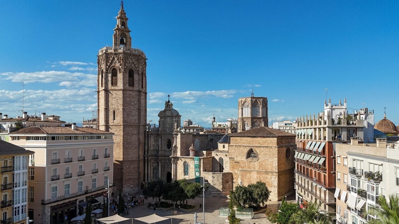 Kathedrale von Valencia Blick auf die Kathedrale von Valencia und den Miguelete-Turm auf einem historischen Stadtplatz, umgeben von Wohngebäuden unter einem klaren blauen Himmel.